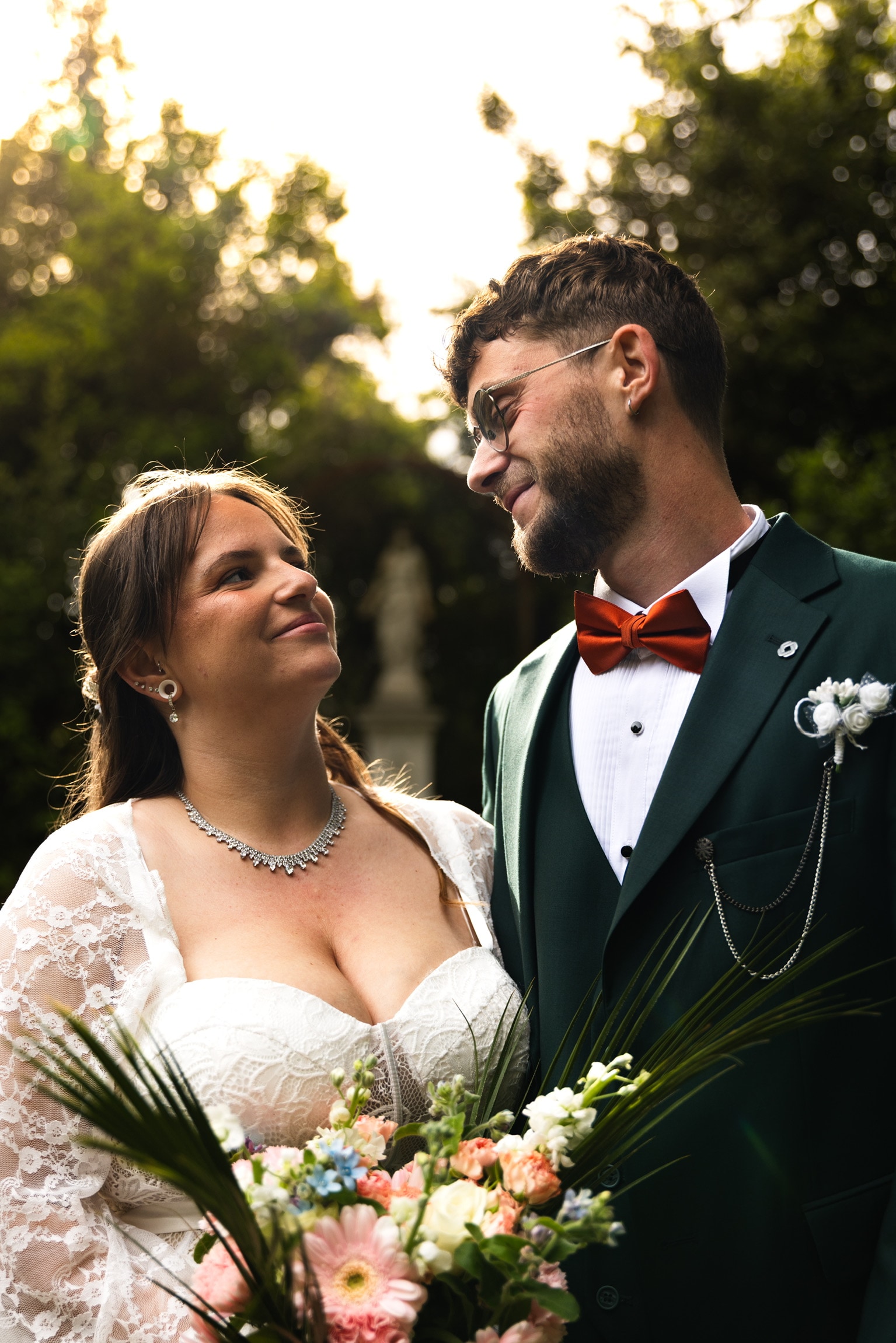 Les mariés échangent un regard complice, bouquet en main